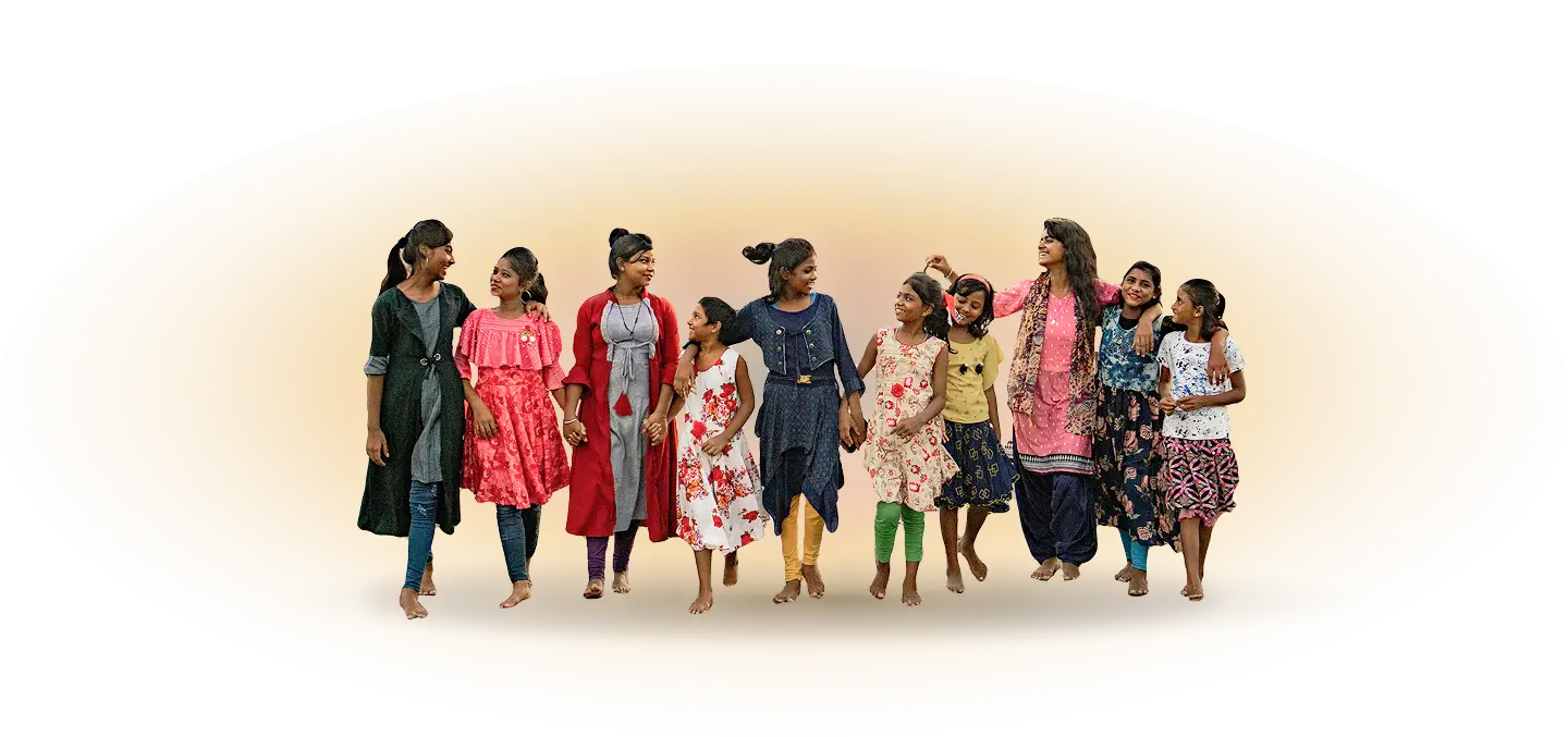 A group of women walk barefoot together, smiling and united holding hands. They wear colorful dresses and appear happy and engaged with each other.